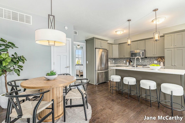 kitchen with visible vents, gray cabinetry, backsplash, stainless steel appliances, and light countertops