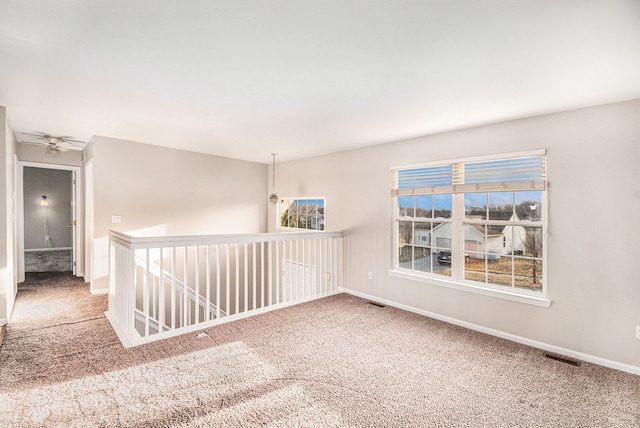 spare room with visible vents, baseboards, and carpet