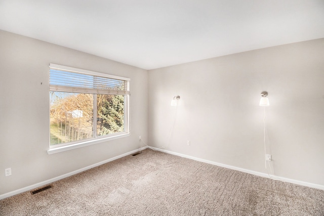 unfurnished room featuring carpet flooring, baseboards, and visible vents