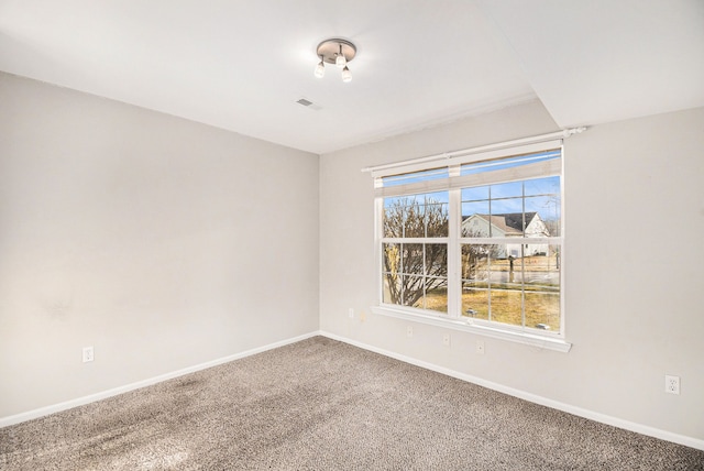 empty room with baseboards, visible vents, and carpet floors