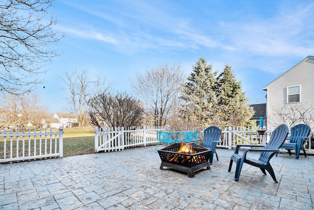 view of patio with an outdoor fire pit and fence