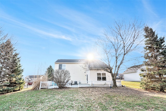 back of house with a lawn and fence