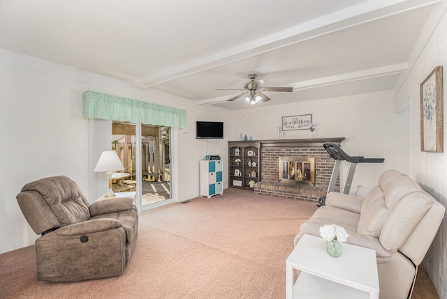 carpeted living room with beamed ceiling, a ceiling fan, and a fireplace