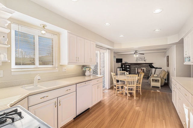 kitchen with a sink, white cabinetry, light wood-type flooring, and white dishwasher