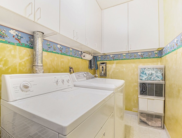 laundry area with cabinet space, light tile patterned flooring, washing machine and dryer, and baseboards