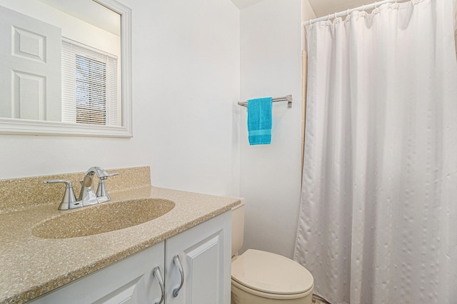 bathroom featuring vanity, curtained shower, and toilet