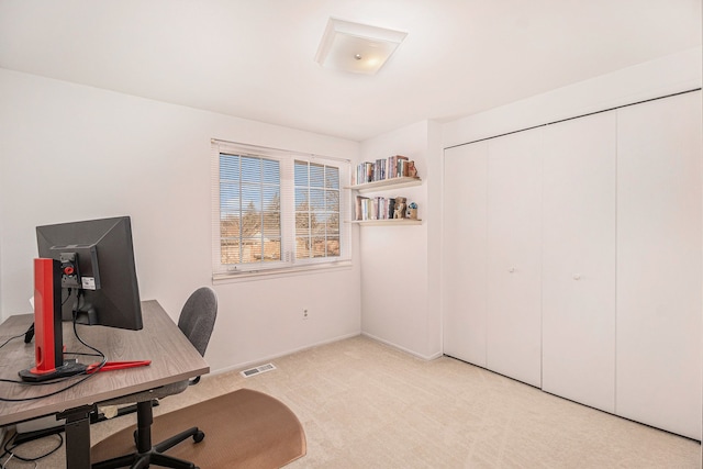 office area with visible vents, light colored carpet, and baseboards