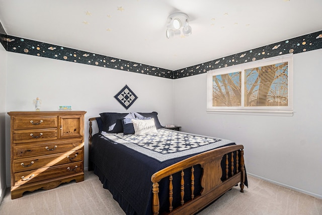 bedroom with light colored carpet and baseboards