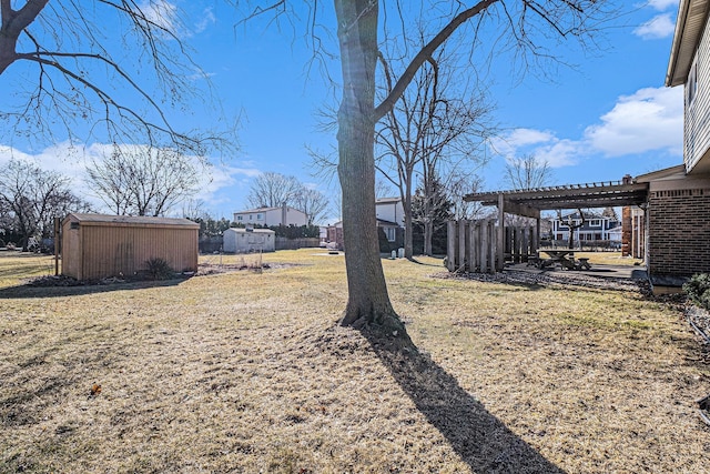 view of yard featuring an outbuilding, a pergola, and a shed