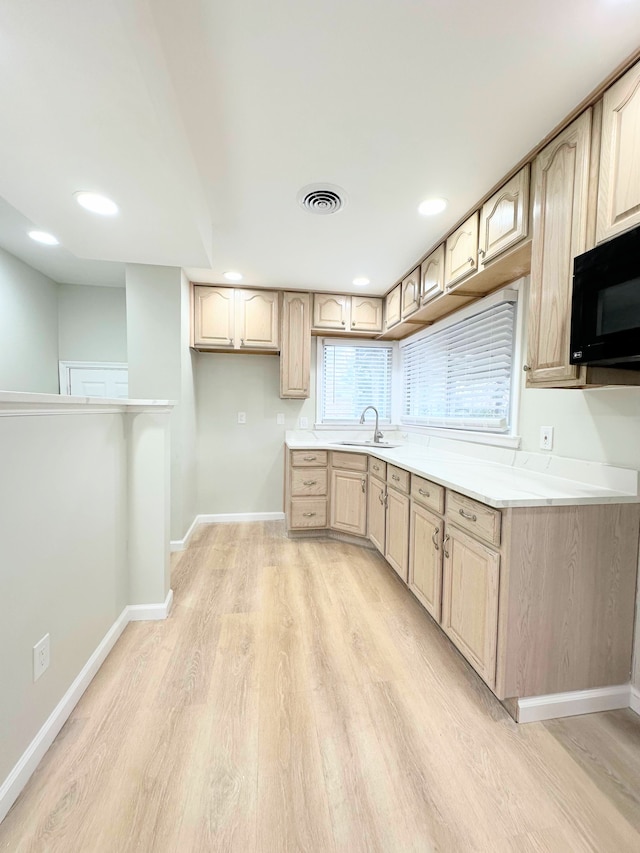 kitchen featuring visible vents, baseboards, light wood-style floors, and black microwave