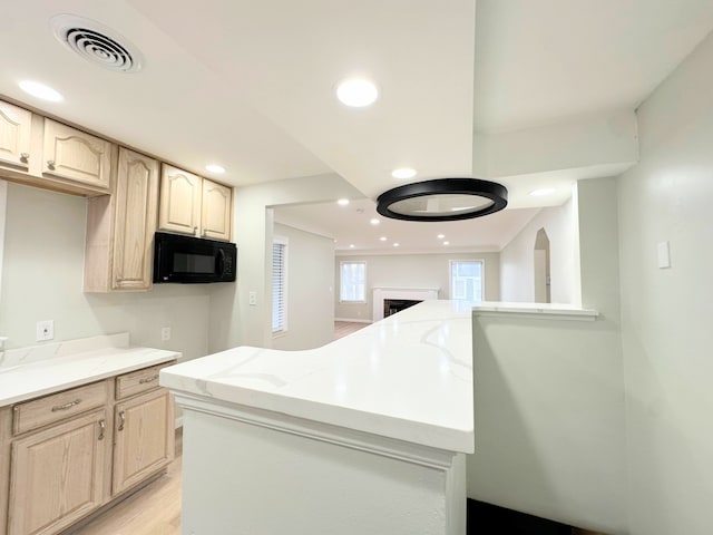 kitchen with visible vents, black microwave, light stone countertops, recessed lighting, and light wood-style floors