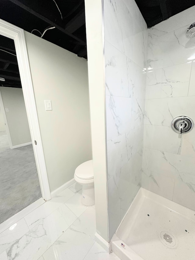 bathroom with baseboards, marble finish floor, and a shower stall