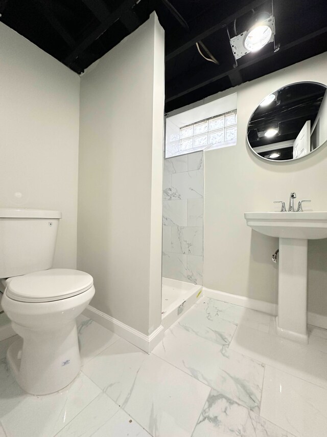 full bathroom featuring marble finish floor, a stall shower, toilet, and baseboards