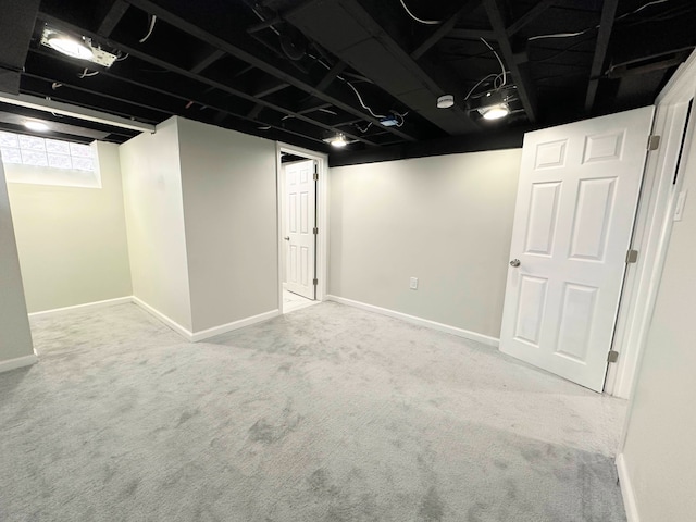 basement featuring baseboards and carpet