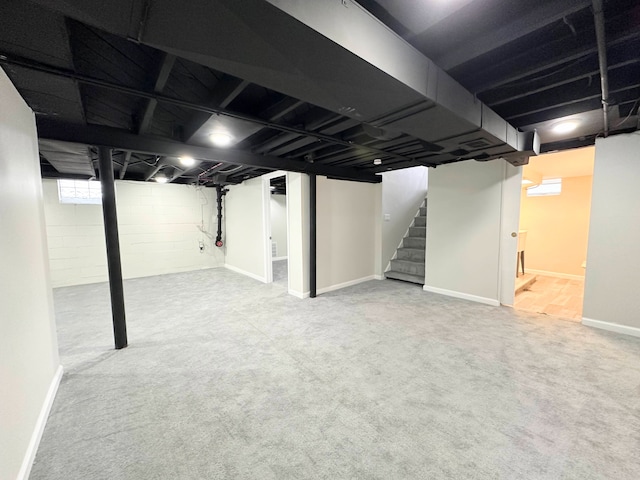 basement featuring stairway, carpet floors, and baseboards