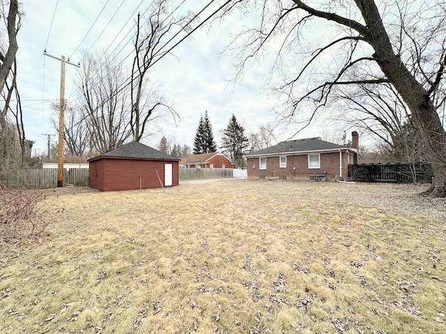 view of yard featuring an outbuilding and fence