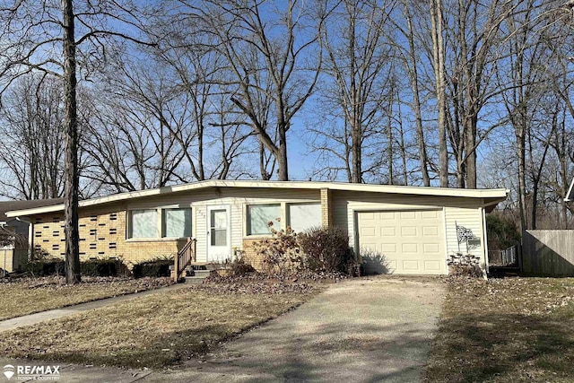 view of front facade featuring aphalt driveway, brick siding, an attached garage, and fence