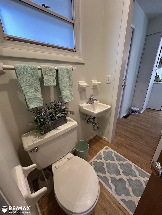 bathroom featuring a sink, toilet, and wood finished floors