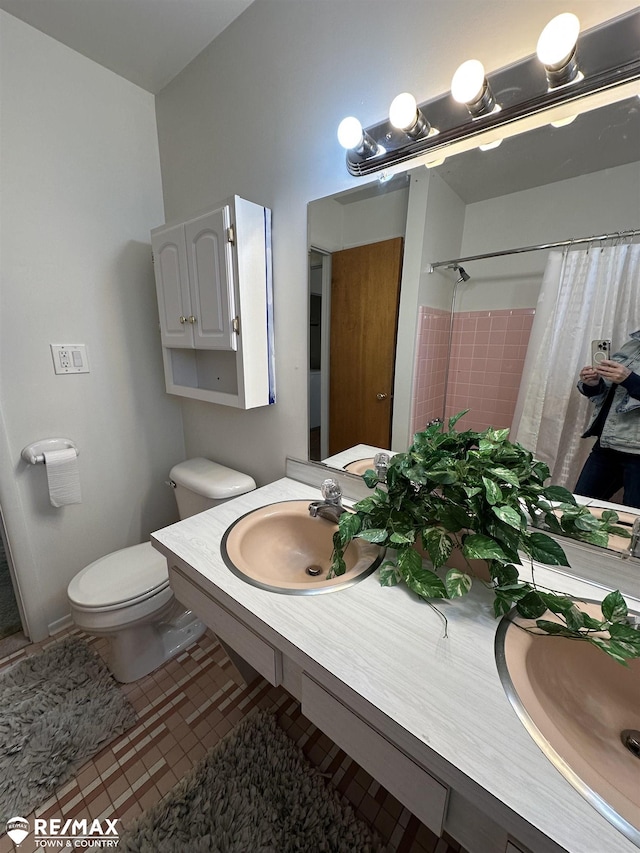 bathroom with tile patterned floors, curtained shower, toilet, and vanity