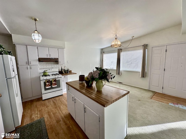 kitchen with under cabinet range hood, white appliances, white cabinets, decorative backsplash, and wooden counters