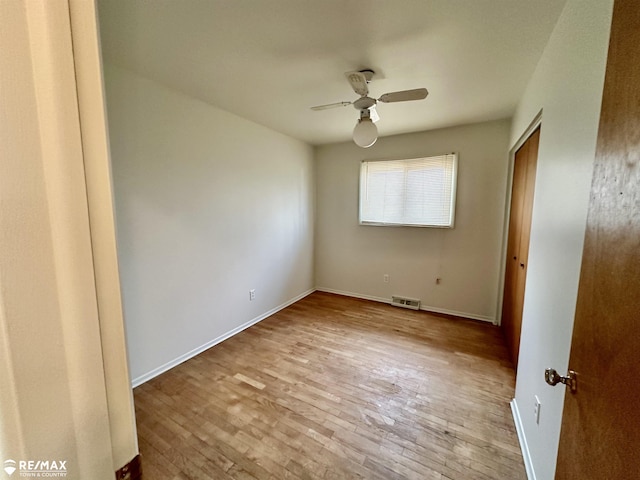 unfurnished bedroom featuring visible vents, hardwood / wood-style flooring, a closet, baseboards, and ceiling fan