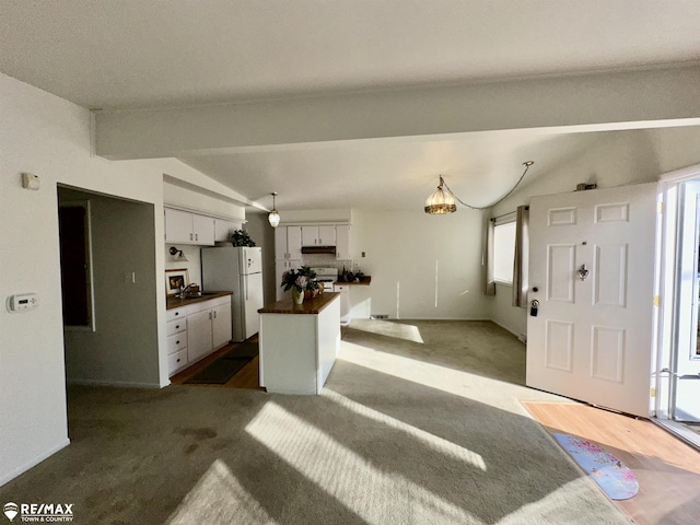 kitchen featuring dark carpet, white appliances, a kitchen island, and vaulted ceiling