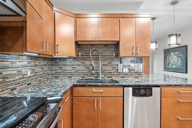 kitchen with dark stone counters, a sink, decorative backsplash, stainless steel appliances, and pendant lighting