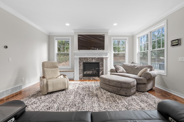 living area featuring visible vents, crown molding, and wood finished floors