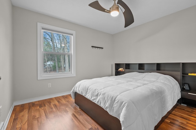 bedroom with baseboards, wood finished floors, and a ceiling fan