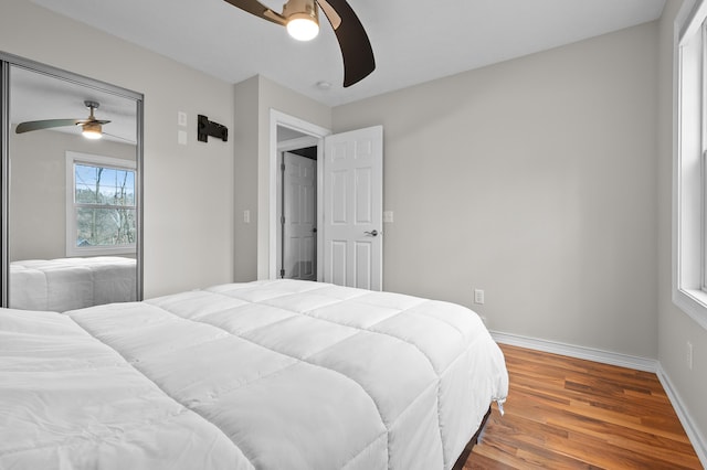 bedroom with ceiling fan, baseboards, and wood finished floors