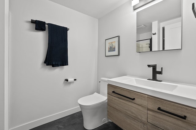 bathroom featuring vanity, toilet, baseboards, and walk in shower