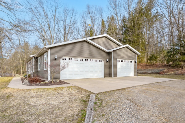 view of side of property featuring a garage and concrete driveway