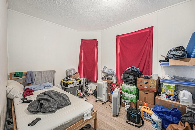 bedroom with a textured ceiling and wood finished floors