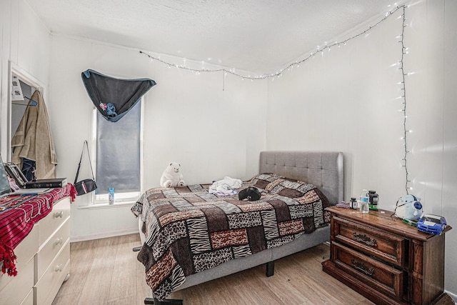 bedroom featuring a textured ceiling and light wood-type flooring