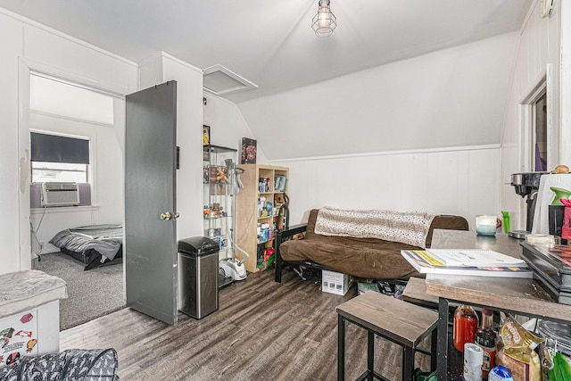 interior space featuring cooling unit, lofted ceiling, attic access, and wood finished floors