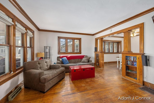 living room featuring wood finished floors, visible vents, and baseboards