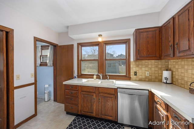 kitchen with a sink, light countertops, decorative backsplash, light floors, and dishwasher