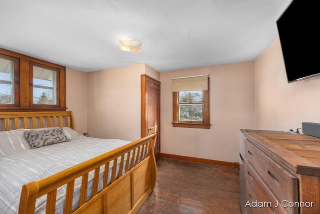 bedroom featuring baseboards and dark wood-style flooring