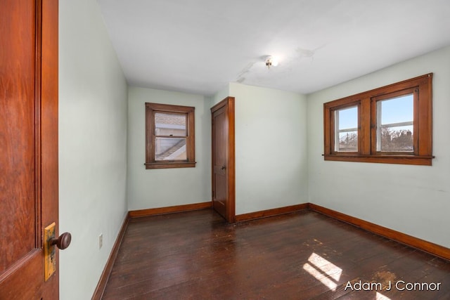 empty room with dark wood-style floors and baseboards