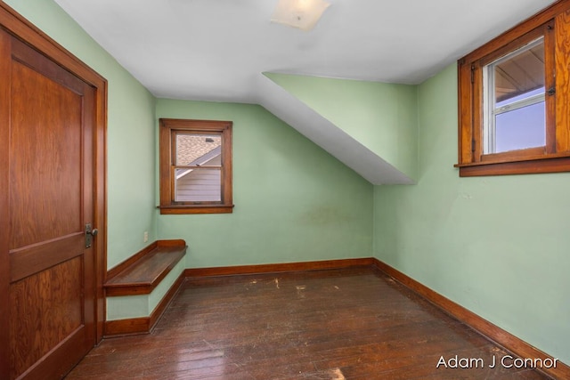 additional living space with baseboards, hardwood / wood-style floors, and vaulted ceiling