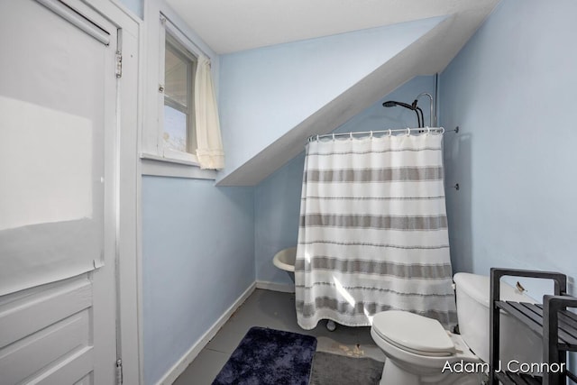 bathroom with baseboards, toilet, and a shower with curtain