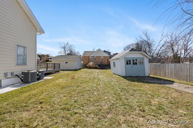 view of yard with cooling unit, an outdoor structure, a shed, and fence