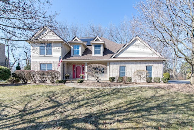 view of front of home featuring a front yard, a porch, and brick siding