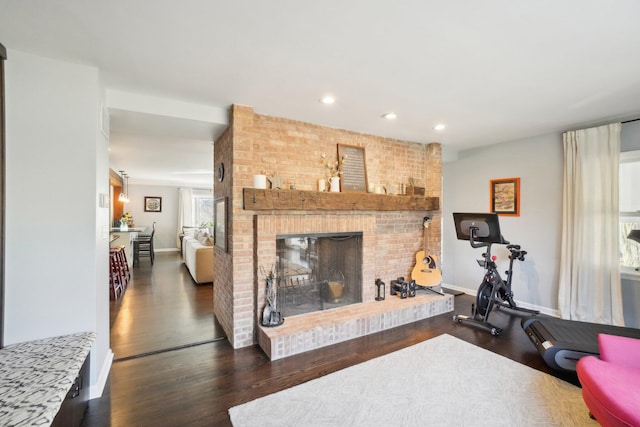 workout area with recessed lighting, baseboards, a brick fireplace, and wood finished floors