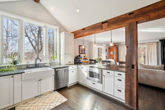 kitchen with visible vents, a sink, dark countertops, dark wood-style floors, and appliances with stainless steel finishes