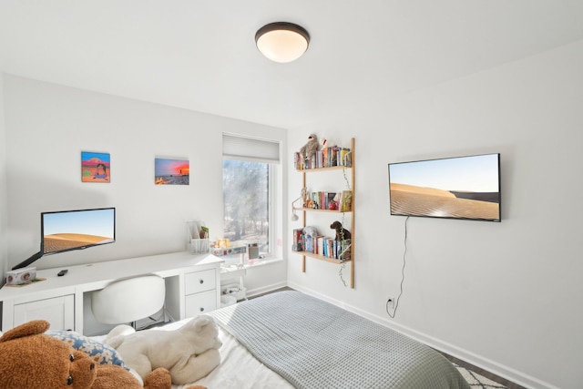 bedroom with built in desk and baseboards