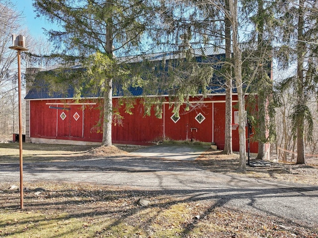 view of barn with dirt driveway