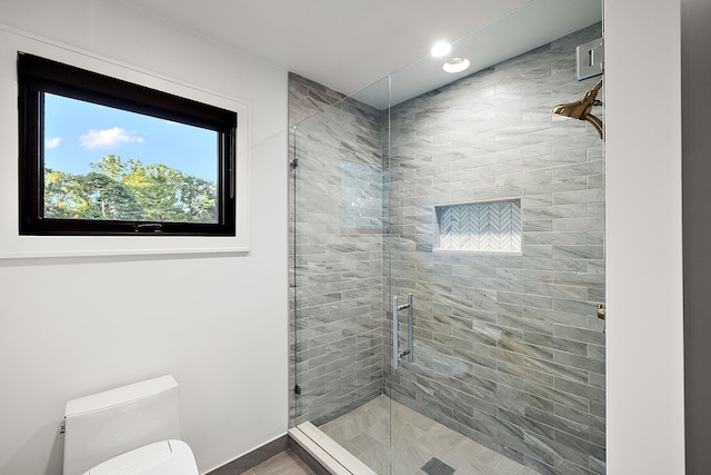 bathroom with a shower stall and toilet