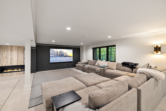 cinema room featuring recessed lighting and a warm lit fireplace