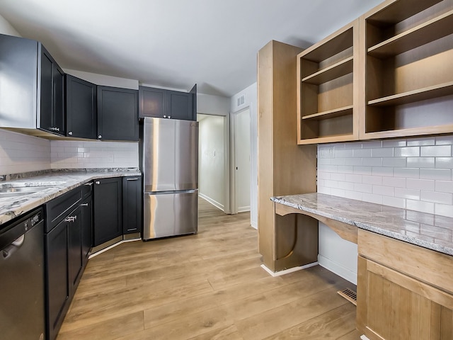 kitchen with baseboards, light stone countertops, built in desk, appliances with stainless steel finishes, and light wood-style floors